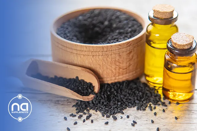 blurry shot for black seed oil with seeds all over the table