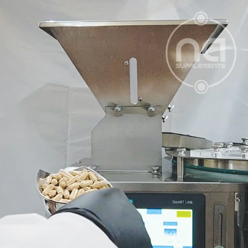 na supplement technician loading single discharge chute pill counting machine with capsules